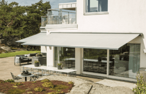 Terrassmarkis TX8300 monterad på villa som ger effektivt solskydd för uteplats och fasad.